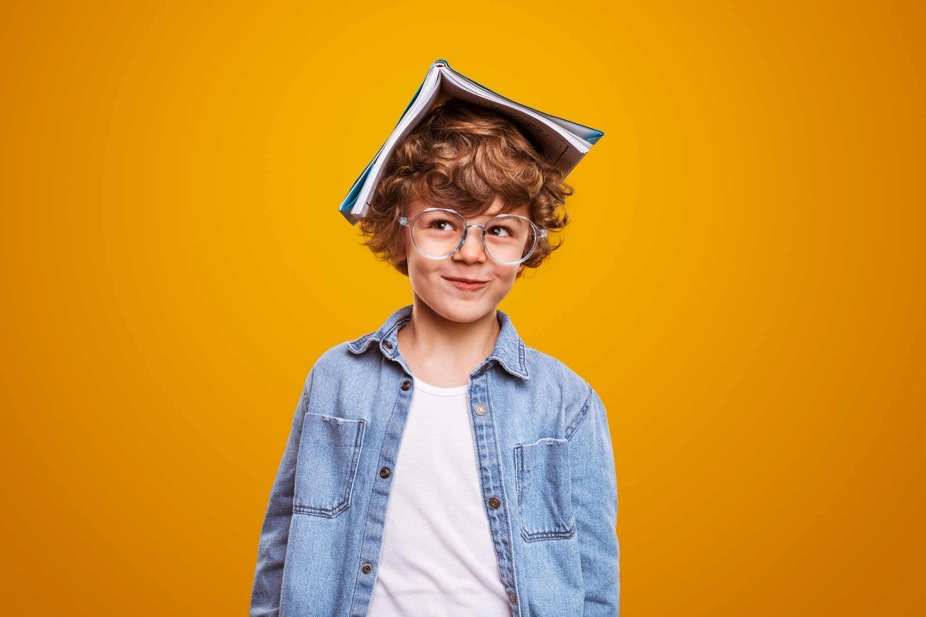 Junge mit Buch auf dem Kopf